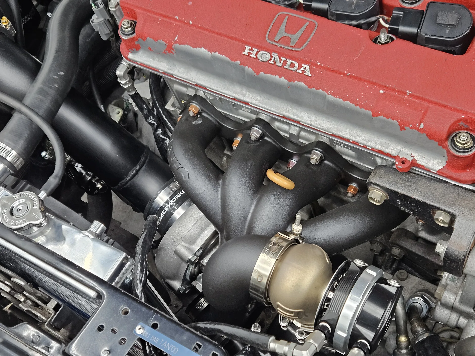 Coated low-mount V-band exhaust manifold feeding the Garrett G25-550 on the B18C