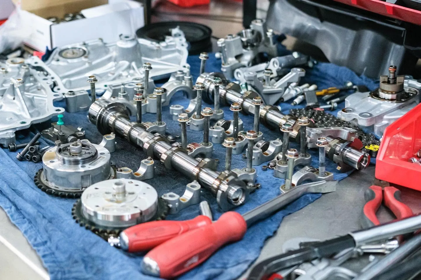 G16E camshafts, cam gears, and timing chain laid out on the bench