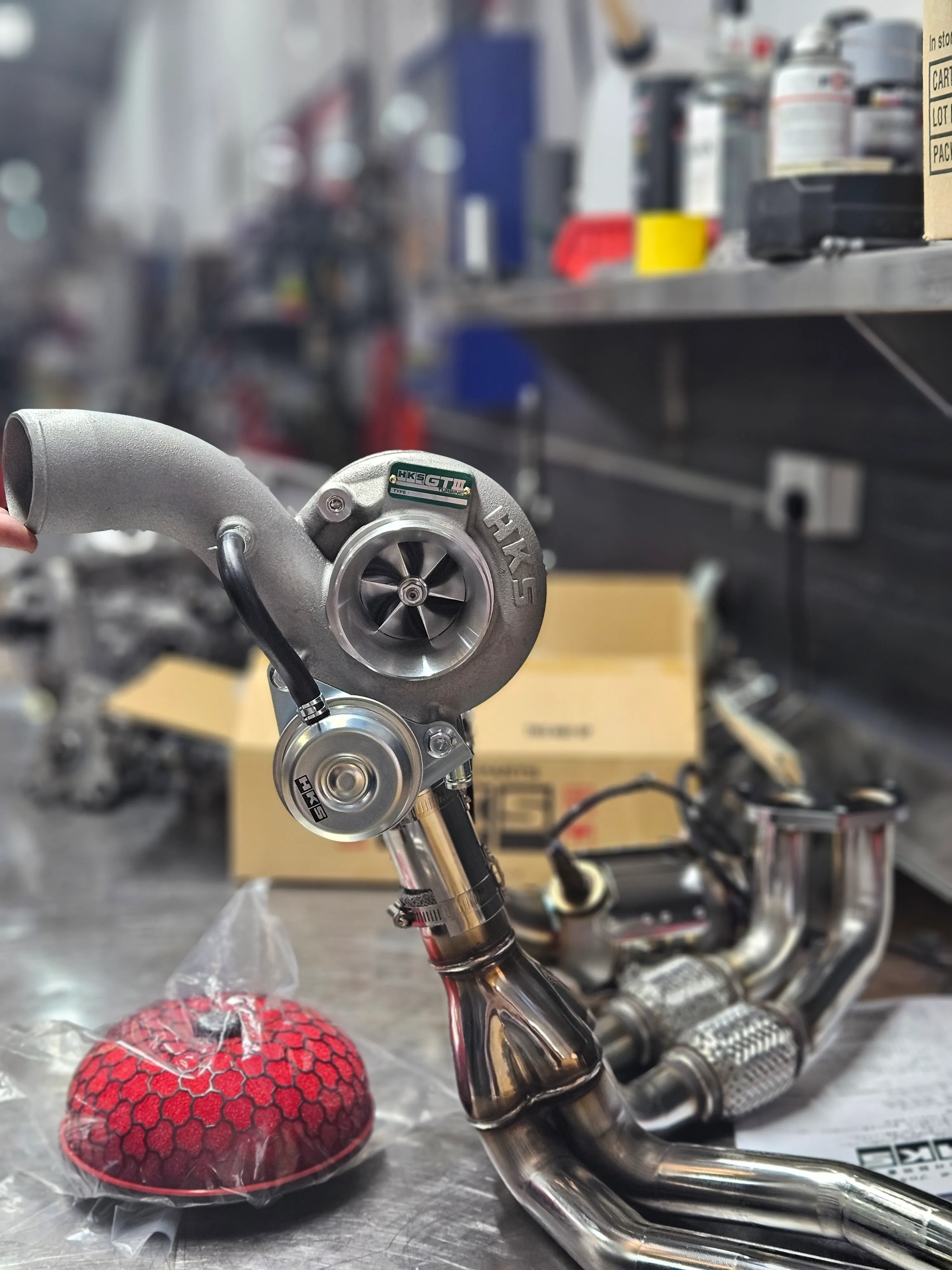 HKS GTIII-RS turbocharger and exhaust manifold components laid out before installation