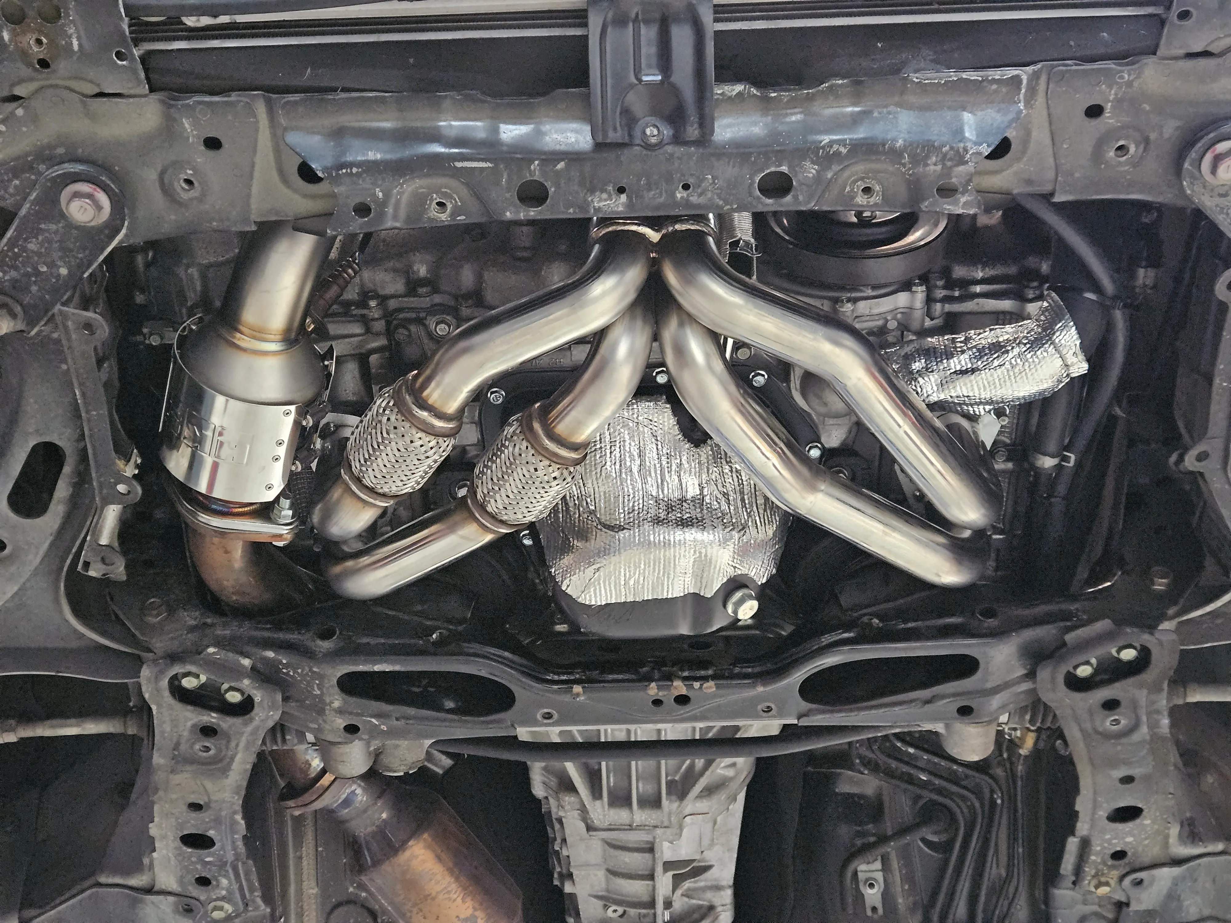 HKS tubular exhaust manifold installed underneath Toyota 86 with heat shielding