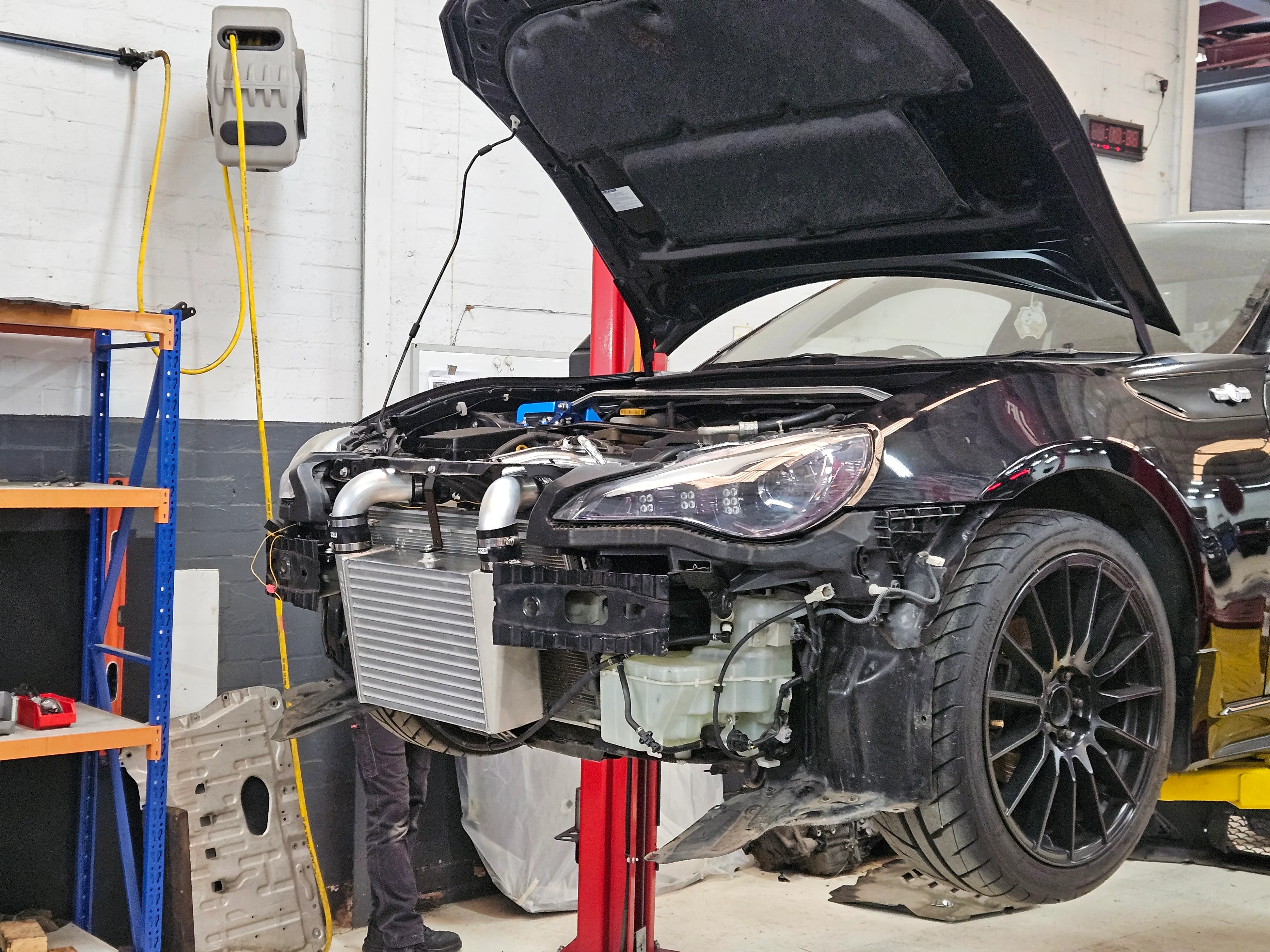 Black Toyota 86 with bumper removed showing HKS front-mount intercooler installed at Revzone Melbourne