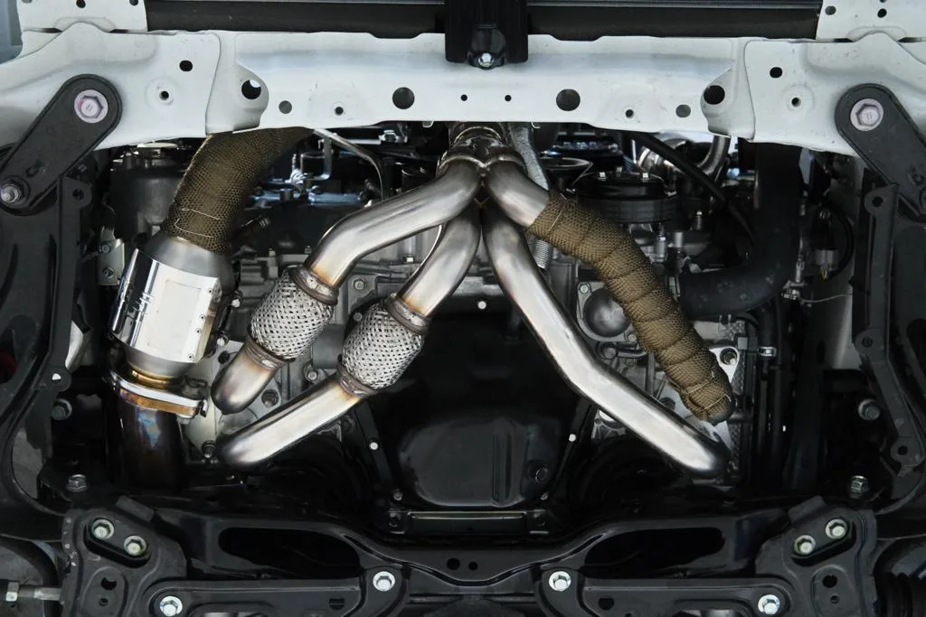 HKS turbo exhaust manifold with heat-wrapped runners viewed from underneath Subaru BRZ ZD8