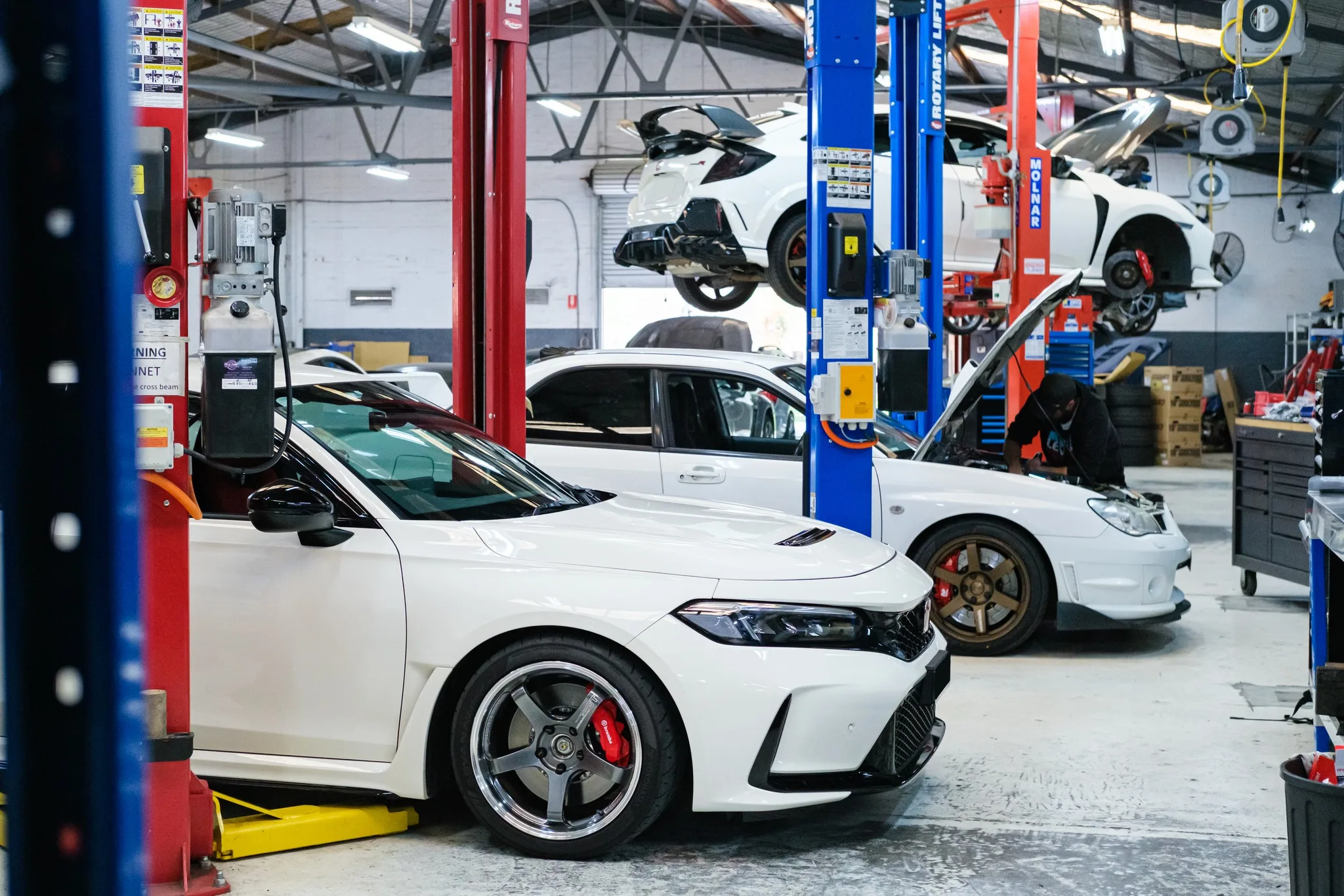 Honda Civic Type R FL5 on the workshop floor at Revzone alongside other performance builds
