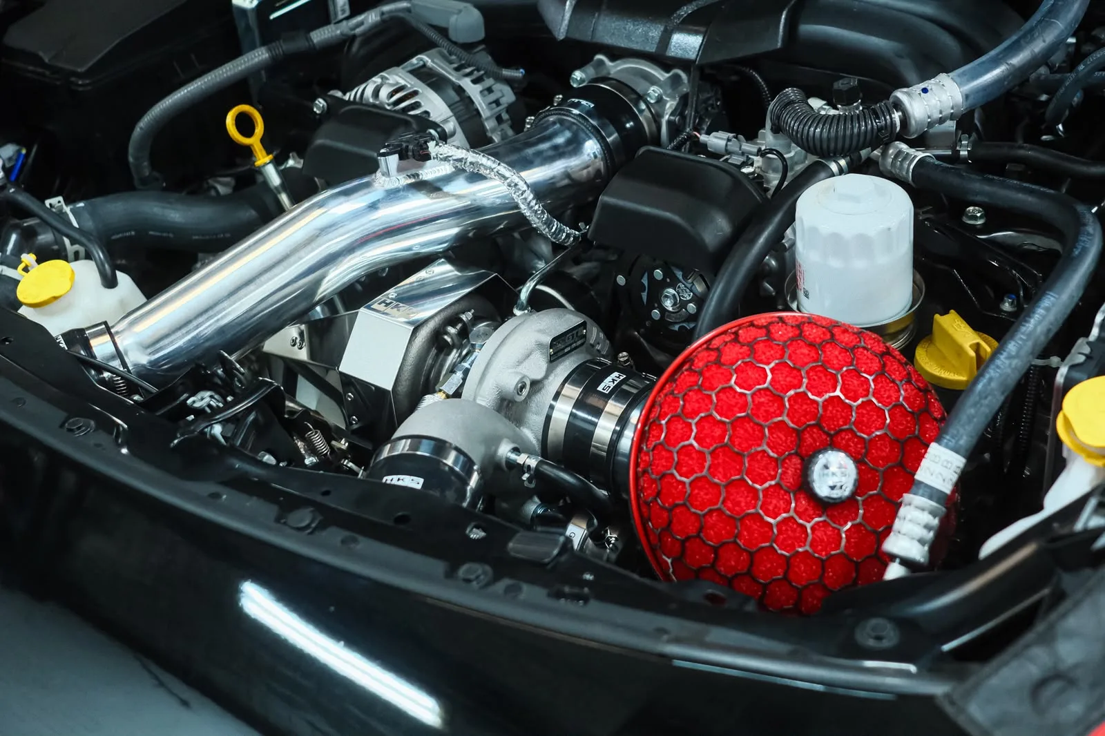 Turbocharged GR86 engine bay with polished charge piping and HKS intake filter