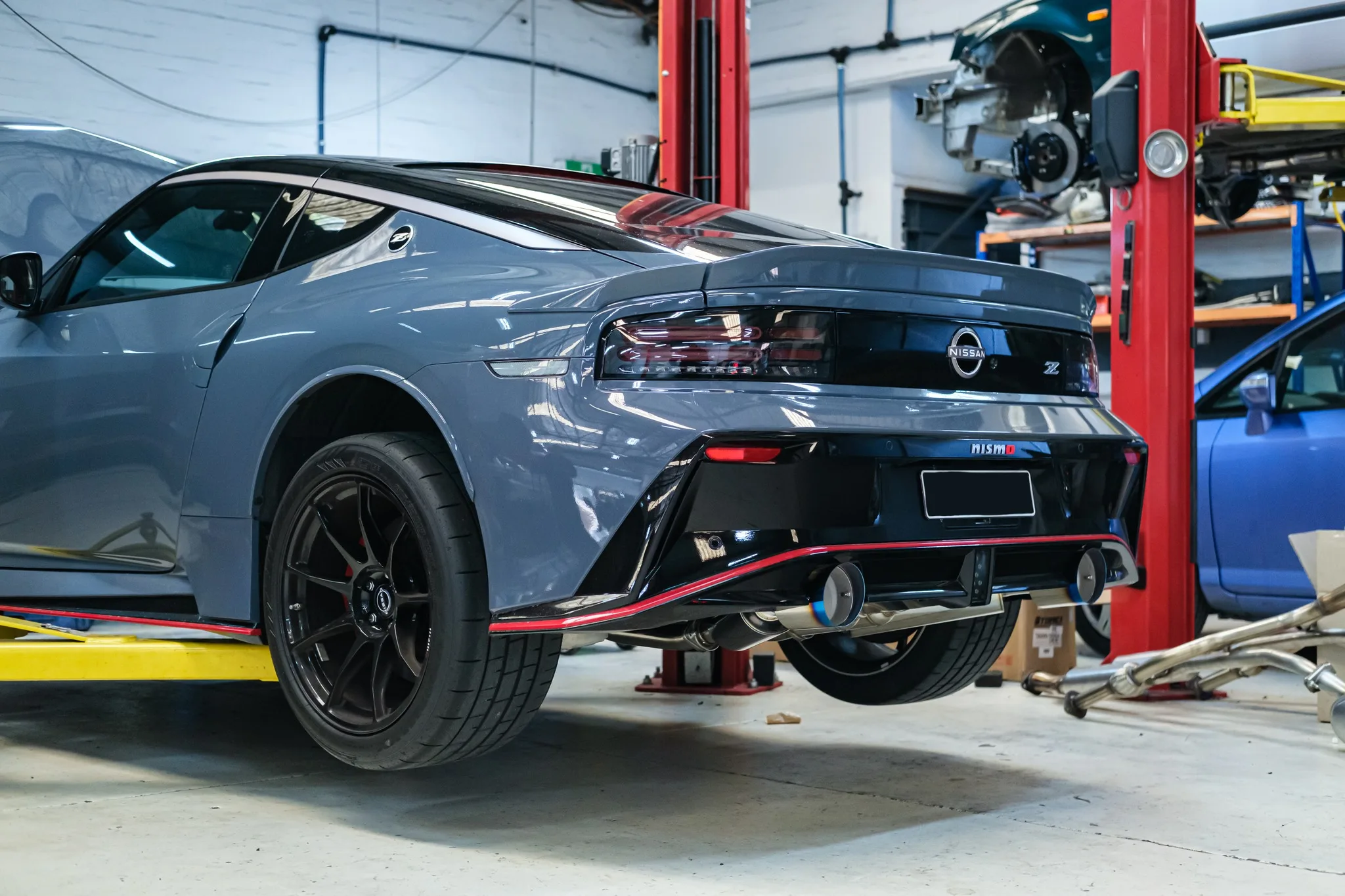 HKS dual muffler titanium tip detail showing burnt blue finish on Nissan Z NISMO
