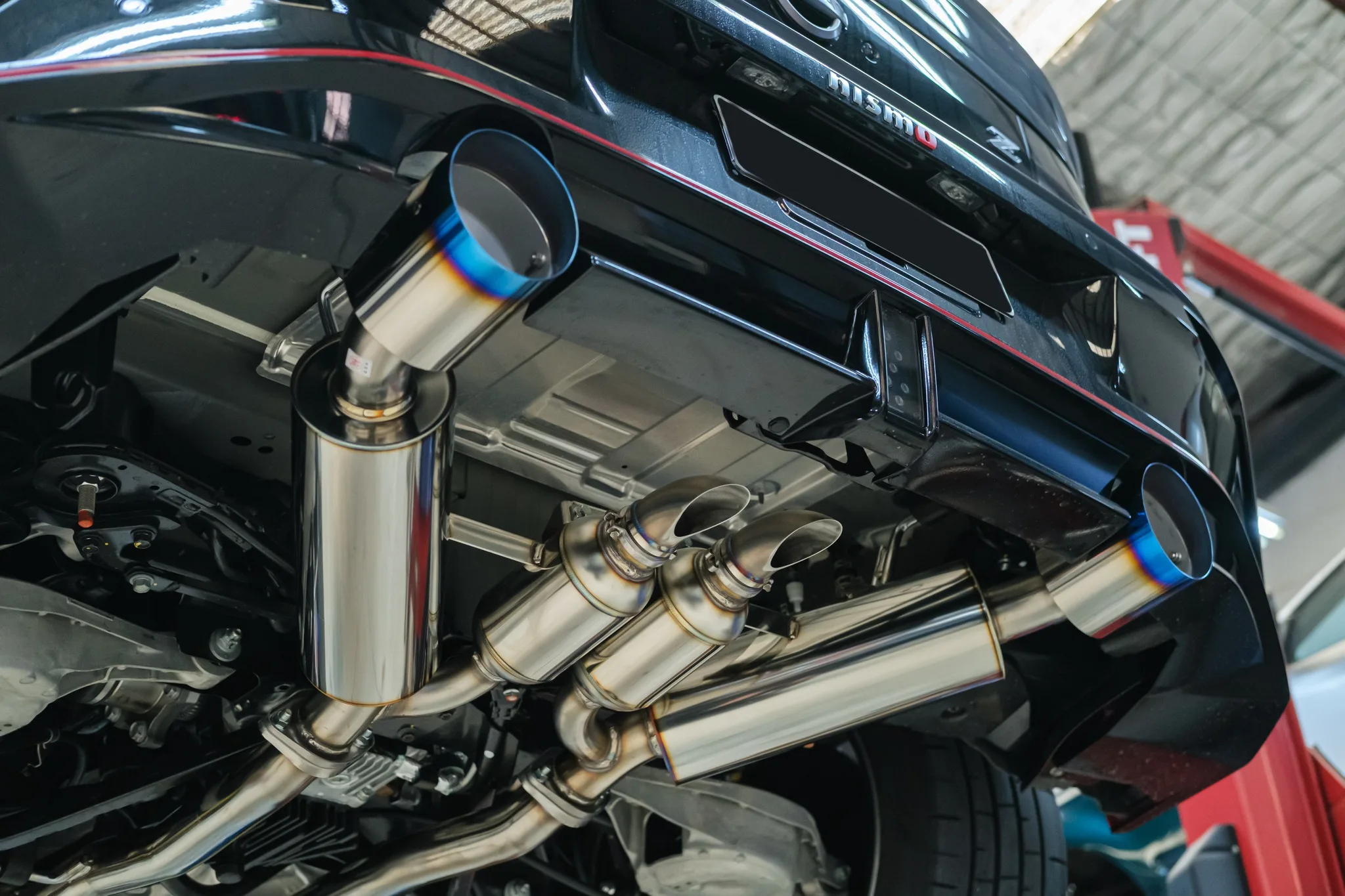 Full underbody view of HKS dual muffler catback exhaust on Nissan Z NISMO