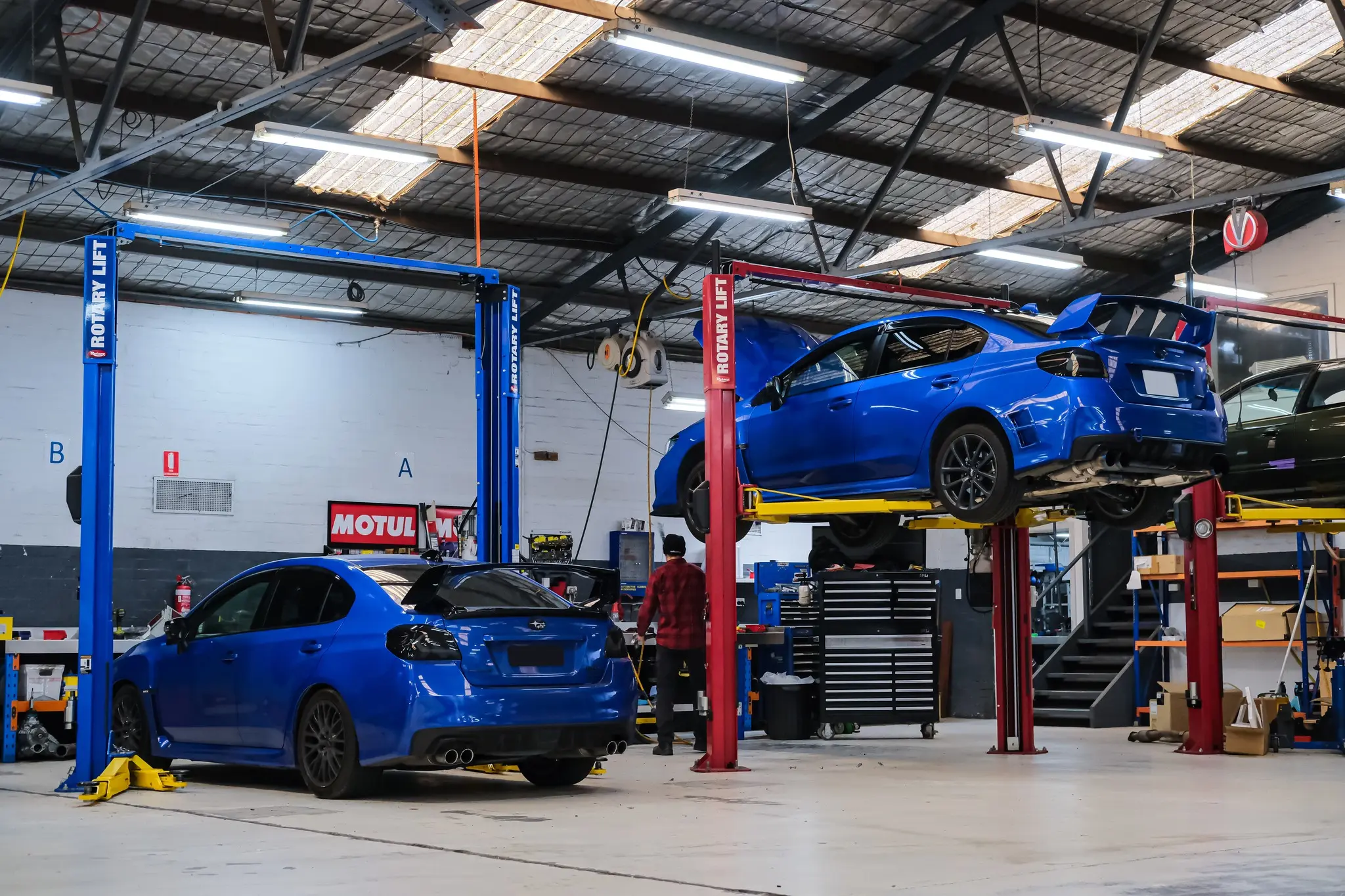 Two blue Subaru WRX VAs side by side in the Revzone Melbourne workshop