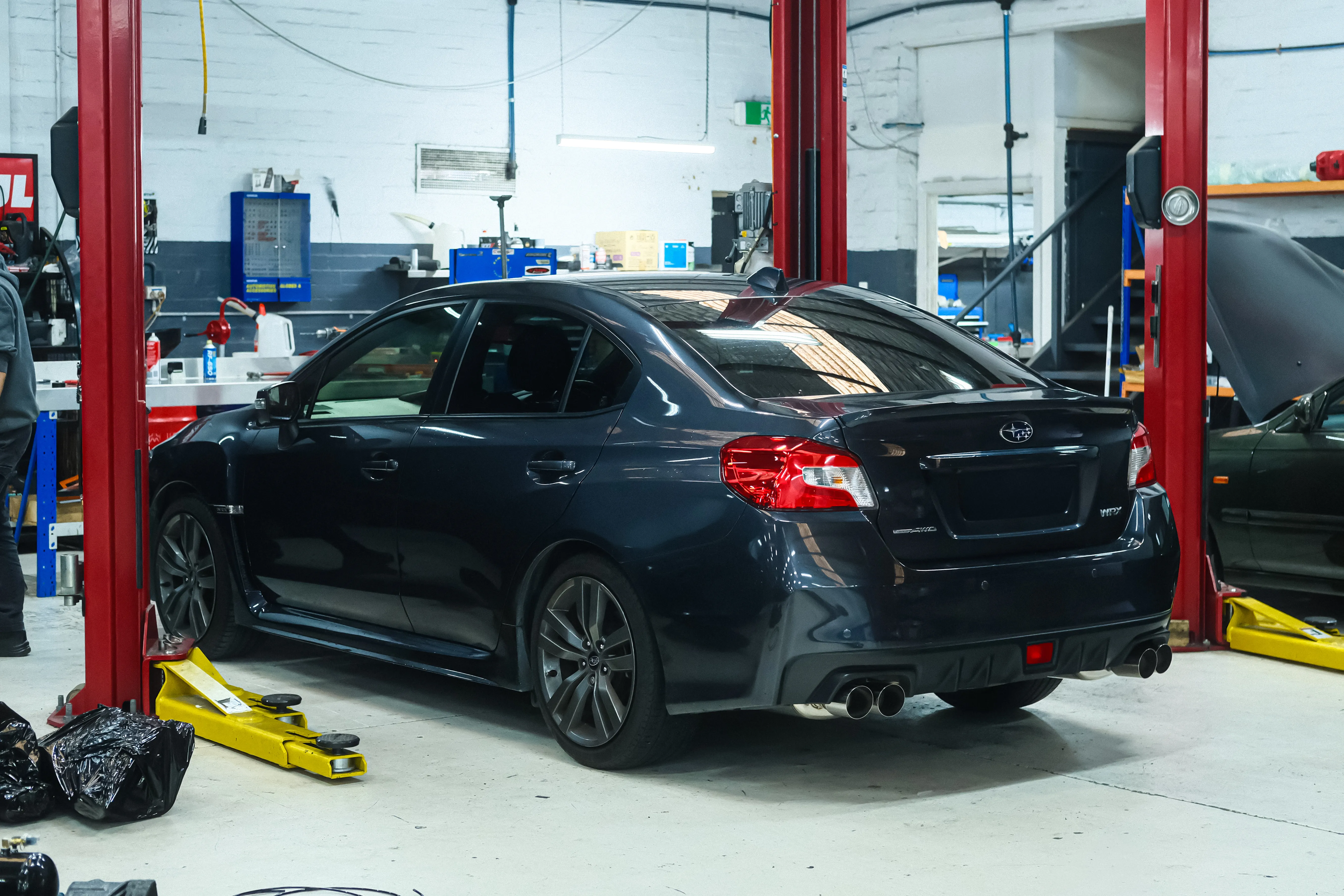 Subaru WRX VA on the hoist during HKS Legamax exhaust fitting